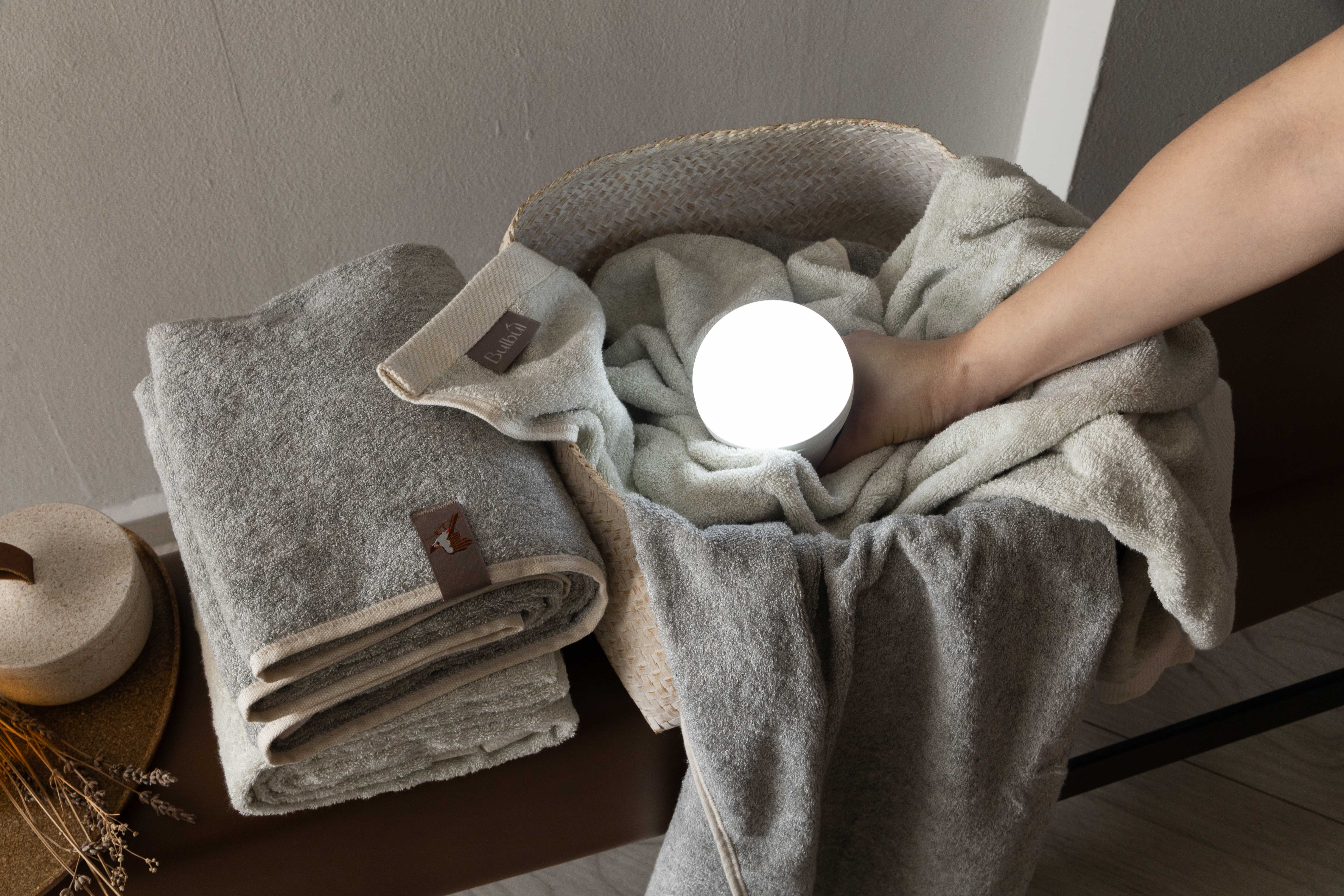 Folded towels on a bench with a diffuser