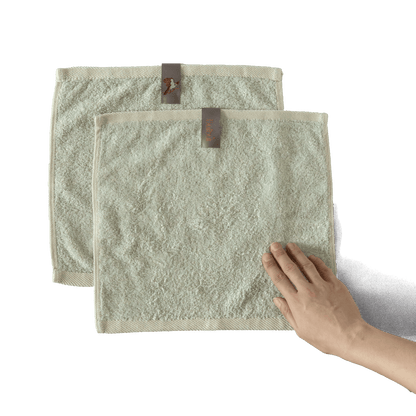 Bulbul Self-sanitizing Premium Copper Face Towel shown in beige color with hand for scale, antibacterial and odour-resistant washcloth for home use.
